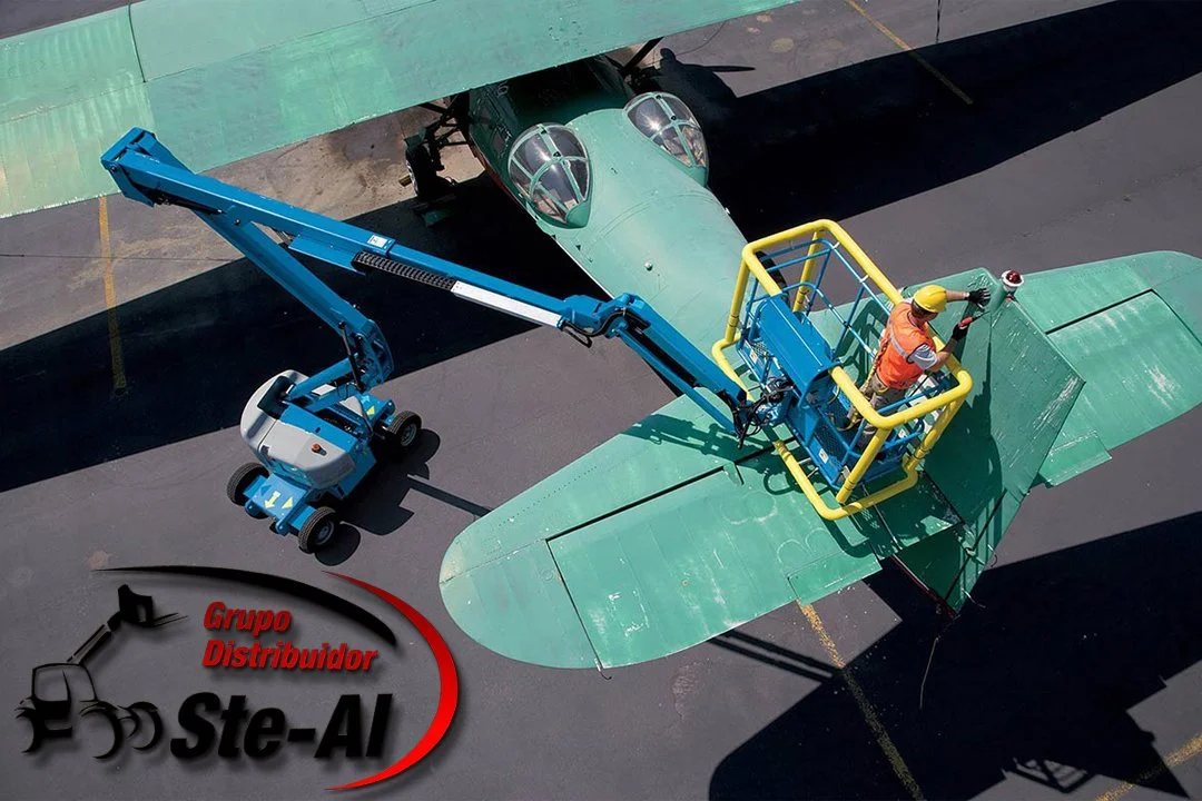 Trabajador en una plataforma elevadora inspeccionando un avión verde en un aeropuerto