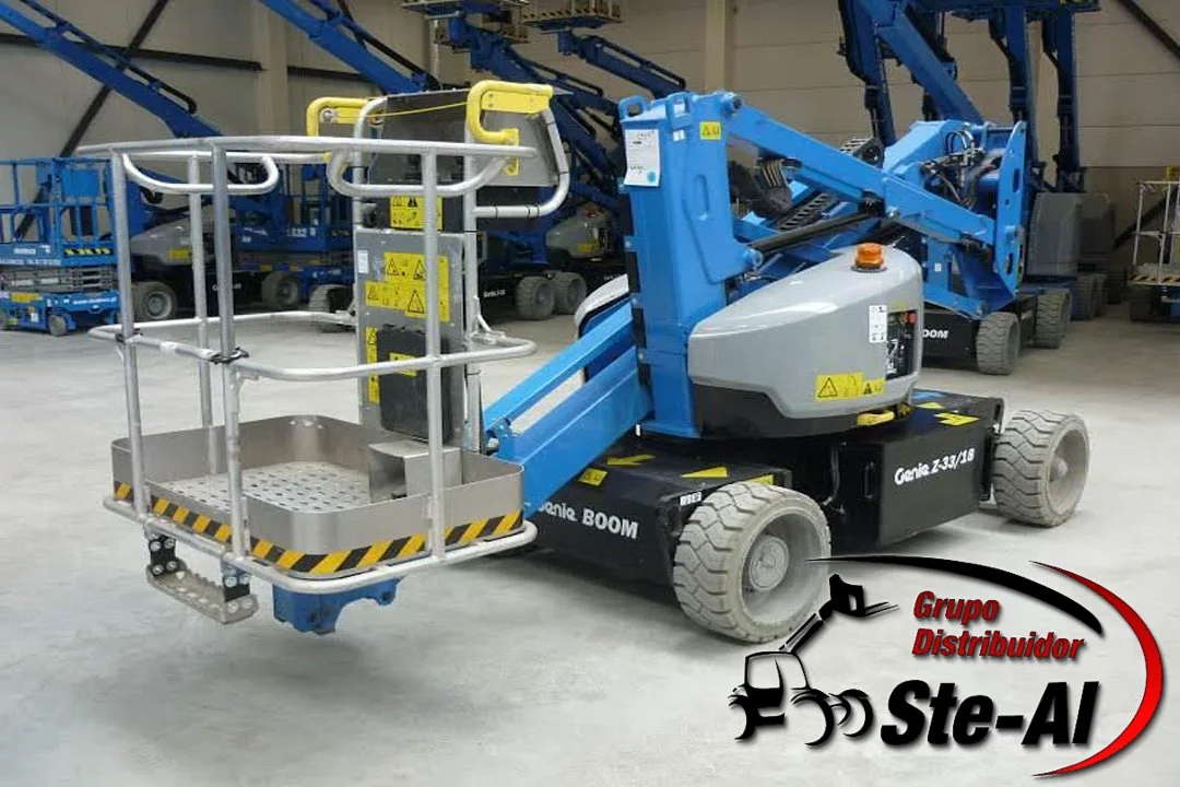 Plataforma elevadora azul en un almacén con otros equipos similares en el fondo.